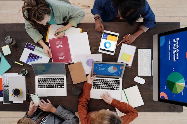 People around a table discussing marketing on laptops